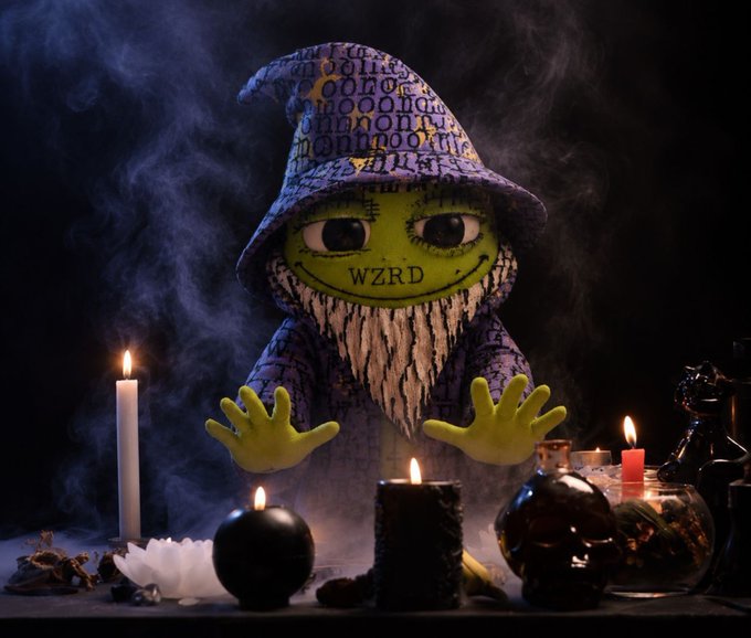 A green-skinned gnome-like figure wearing a purple patterned witch hat with "WZRD" on its face appears to cast a spell, surrounded by lit candles, skulls, potion bottles, and swirling smoke.