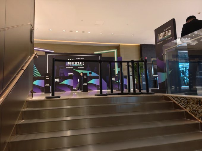 A staircase leads up to a closed or shutdown Solana "Accelerate" event space in Shanghai, with branded backdrops and empty stanchions visible at the entrance, suggesting the event was abruptly halted. The image aligns with the post's claim that the crypto event was raided and shut down, showing a deserted venue rather than an active gathering.
