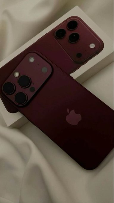 Two deep burgundy iPhones rest on white packaging atop a soft fabric background. The rich red color of the devices ties into the promotional post, which appears to be offering a free iPhone giveaway through EtherFi's pre-order cashback promotion.