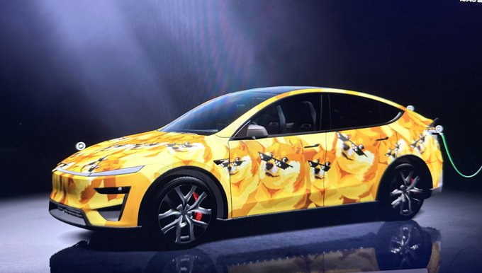 The image features a yellow car with a unique design of dogs painted on its side. The word "dog" appears multiple times on the car's exterior, creating an interesting and eye-catching pattern. The car is parked indoors, possibly at a showroom or exhibition, as indicated by the presence of a green hose nearby.