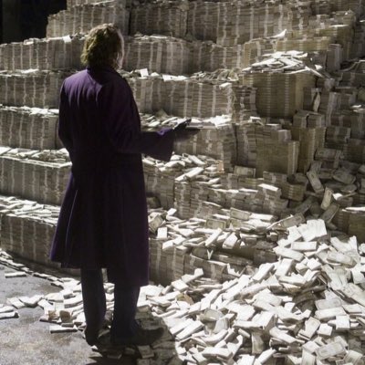 A surreal image showing a person in a long purple coat standing in front of massive stacks of bundled paper or currency, with loose bills scattered across the floor in what appears to be a warehouse or printing facility.