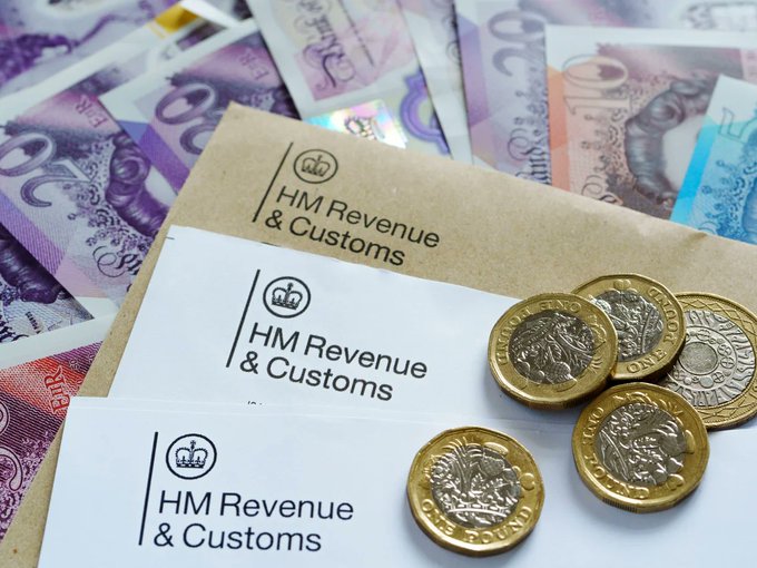 HM Revenue & Customs correspondence rests atop a fan of £20 banknotes and a scattering of £1 and £2 coins. The image visually reinforces the post's theme by depicting the UK tax authority alongside British currency, symbolizing the government's expanding power to seize assets amid mounting global debt.