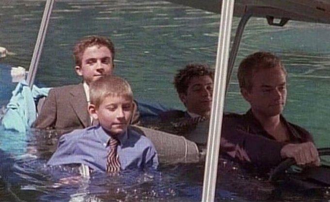 Four men, fully dressed in suits and formal attire, sit submerged up to their chests in a lake inside a sinking car, maintaining calm, resigned expressions as the vehicle fills with water.

The image mirrors the post's theme of stubborn loyalty amid a sinking investment—just as the men refuse to abandon their waterlogged vehicle, memecoin holders stay committed to their community even as the token's value plummets.