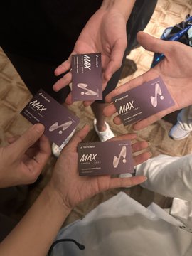 Four hands hold up purple business cards reading "MAX" from "Hyperliquid Vaults" — likely autograph-style cards from the platform's top traders featured in the post about meeting Hyperliquid community stars at a casual gathering.