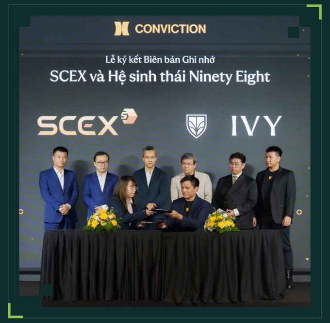 A signing ceremony featuring executives exchanging documents at a table, with a backdrop reading 'CONVICTION' and 'SCEX và Hệ sinh thái Ninety Eight' alongside SCEX and IVY logos.