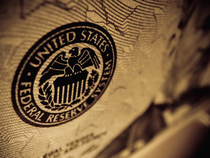 A close-up sepia-toned image of a United States Federal Reserve seal printed on what appears to be currency paper.