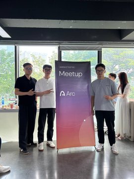 Two men pose on either side of a rollup banner for a 'Web3 Testing Meetup' hosted by 'Arc' at what appears to be a social event.