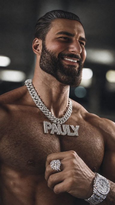 A muscular, shirtless man with a beard smiles while showcasing an iced-out "PAULY" pendant, a matching ring, and a diamond watch, embodying the flex of confidence and wealth referenced in the post celebrating $Pauly's potential 30M market cap.