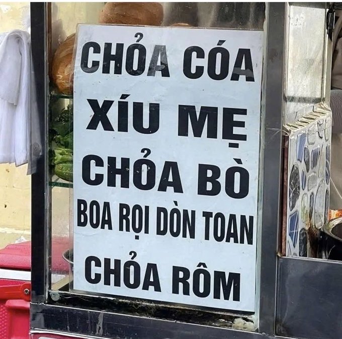 A Vietnamese sign lists menu items in bold black text: "CHỎA CÓA", "XÍU MỆ", "CHỎA BÒ", "BOA RỌI DÒN TOAN", and "CHỎA RỒM".