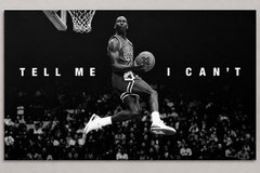 A black and white image of basketball player Michael Jordan in mid-air about to dunk, with the text 'TELL ME I CAN'T'.