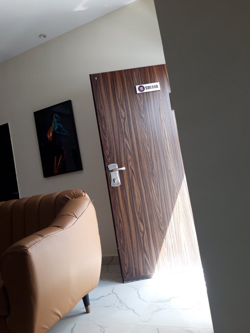 An interior view shows a wooden door with a 'SOLANA' nameplate next to a tan leather tufted armchair in a modern room with white marble flooring and abstract wall art.