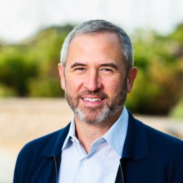 Brad Garlinghouse, CEO of Ripple, pictured in a professional headshot wearing a navy jacket over a light blue shirt, smiling confidently against an outdoor backdrop.

The image directly illustrates the accompanying post, showing the executive referenced in the commentary about the CLARITY Act and its potential impact on institutional XRP adoption.