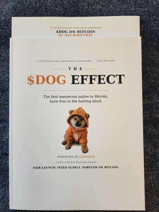 A white cover of a 'CRYPTOLUTION RESEARCH HANDBOOK · 2026 EDITION' titled 'THE $DOG EFFECT,' featuring a Shiba Inu dog wearing an orange hoodie with a Bitcoin logo, noting it as the 'first memecoin native to Bitcoin' with a foreword by Leonidas.
