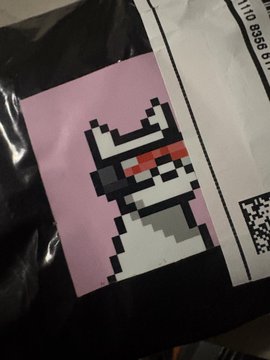 A pixel art cat design printed on a black plastic bag or package, featuring a white and gray cat with red pixel sunglasses on a pink background.