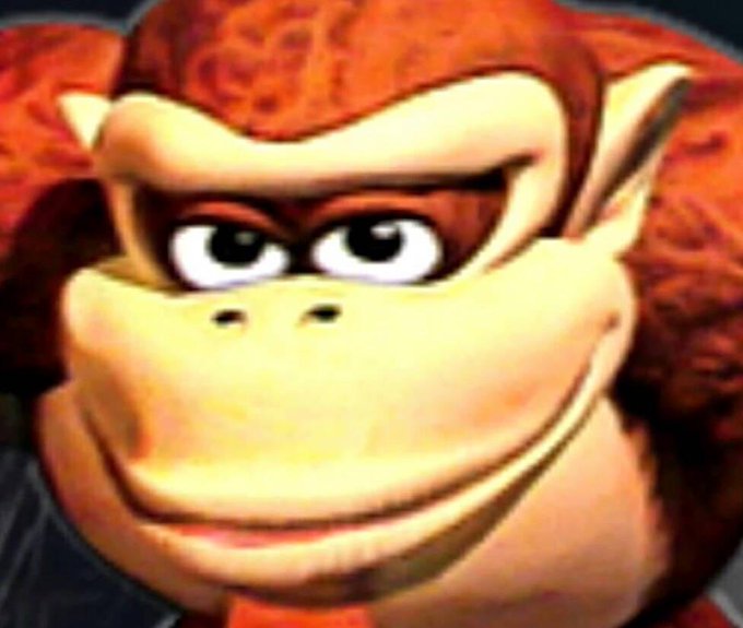 A distorted, unsettling close-up image of Donkey Kong's face with a wide, creepy grin.