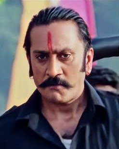 A stern-looking man with slicked-back hair, a thick mustache, and a red tilak on his forehead stares intensely into the camera in what appears to be a cinematic still. The phrase "Vasooli bhai, Vasooli bahen" (a popular Indian slang meaning "pay up, bro/sis") paired with his menacing glare humorously suggests he is the type of unyielding debt collector you'd want to settle dues with.