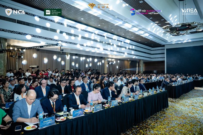 A large conference hall filled with attendees seated at tables, with logos visible for NCA, Vietnam M&A Forum, and VIETNAM INVESTMENT REVIEW at the top.