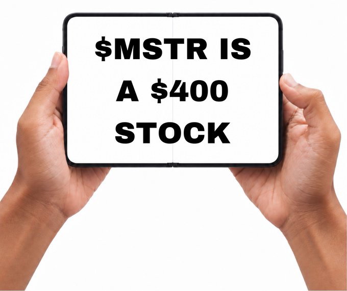 Two hands holding up a tablet that displays the bold text '$MSTR IS A $400 STOCK'.