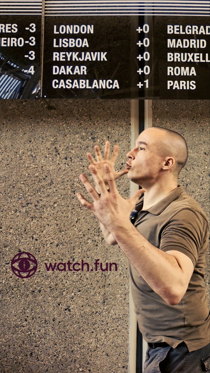A man in a brown polo shirt stands in profile near an airport departures board listing cities like London, Lisboa, Reykjavik, Dakar, Casablanca, Belgrade, Madrid, Brussels, Roma, and Paris with time zone offsets, while a "watch.fun" watermark appears in the lower left.