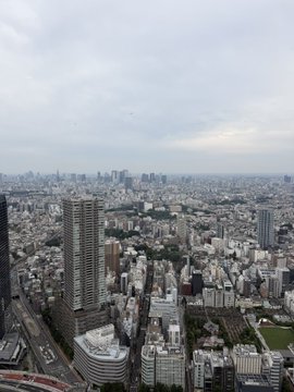 A sprawling cityscape under an overcast sky, viewed from a high vantage point overlooking dense urban architecture.

The image shows a panoramic city view, which appears to be Tokyo, complementing the post that expresses gratitude for an invitation to a BNB Chain event hosted by a prominent entrepreneur in the industry.