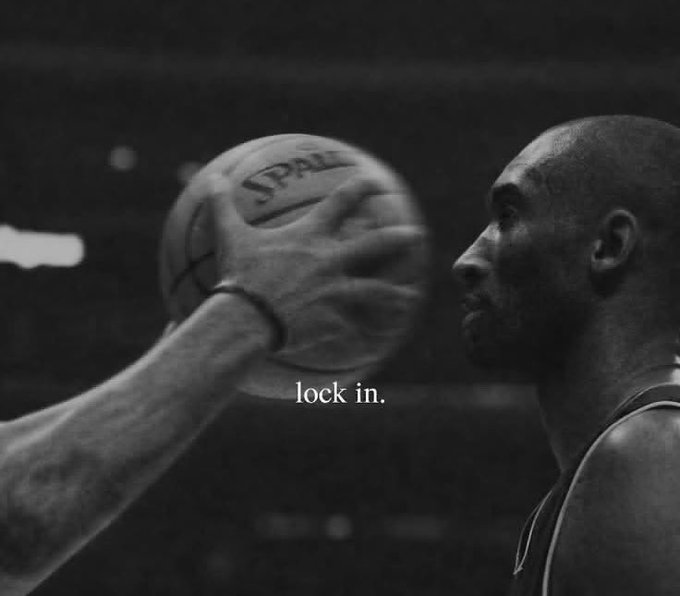 A basketball player in a Lakers jersey (appearing to be Kobe Bryant) focuses intensely on an inbounding Spalding basketball, with the text "lock in." overlaid on the image. The caption of focused determination contrasts ironically with the post's message about sustaining the year on shaky foundations of risk and delusion—suggesting that mental focus alone won't steady an already crumbling base.