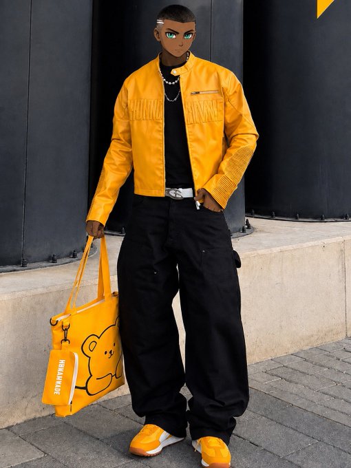 A person poses in streetwear, wearing a yellow leather jacket, black cargo pants, and matching yellow shoes, while holding a yellow bag with a cartoon bear design.