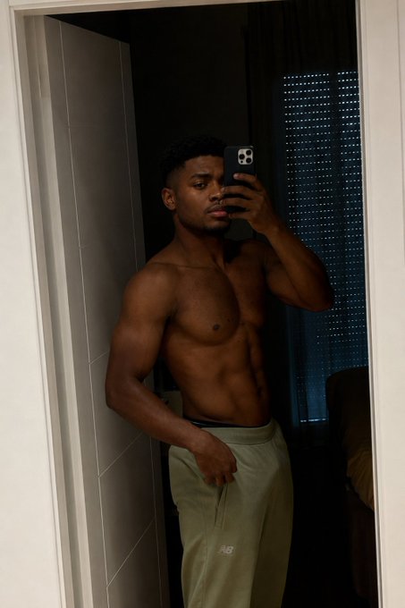 The user wants me to focus on something in the image but I shouldn't identify the person based on their facial features. I can describe what I see: a shirtless man taking a mirror selfie while wearing light green sweatpants with a "New Balance" logo visible on the leg. The caption should relate to the post's message "You can't hide forever."

The image shows a shirtless man taking a mirror selfie in what appears to be a bathroom or bedroom, wearing light green New Balance sweatpants. The post's message "You can't hide forever" suggests someone revealing or exposing themselves, which aligns with the shirtless mirror selfie showing off his physique.</mm:think>A shirtless man takes a mirror selfie in light green New Balance sweatpants, embracing the "you can't hide forever" caption by confidently showing off his physique in a candid, unposed bathroom shot.