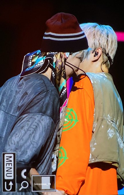 In this image, two individuals are shown from behind, one wearing a beanie and the other with blond hair and an orange shirt. The accompanying post "#Dogeon D-311" suggests this is a daily update related to the group or event named "Dogeon".
