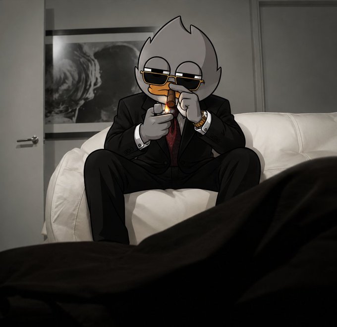 An animated duck character wearing a black suit, red tie, and sunglasses sits on a white couch smoking a cigar and holding a glass.