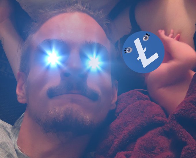 A close-up selfie of a man with glowing blue starburst lights shining from his eyes, next to a blue circular logo with eyes and a stylized 'L'.