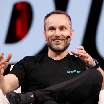 A man wearing a headset microphone and a black T-shirt with the "tether" logo sits smiling with his legs crossed, gesturing with his hands. The Tether branding on his shirt visually reinforces the post's reference to Tether CEO Paolo Ardoino discussing plans to bring USDT onto Bitcoin.