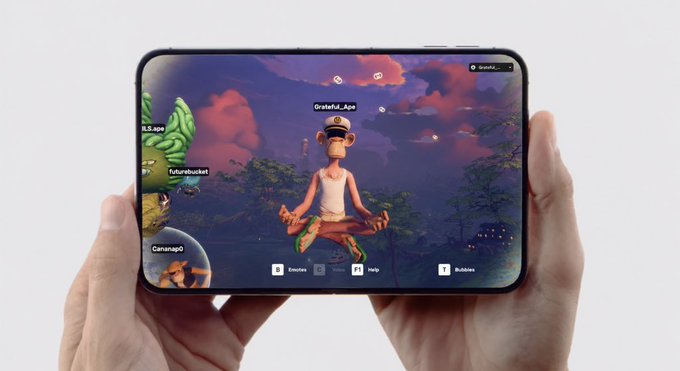 Two hands holding a foldable smartphone displaying an animated monkey character named 'Grateful_Ape' in a meditation pose, with other usernames like 'ILS.ape', 'futurobucket', and 'Carajao' visible on the screen.