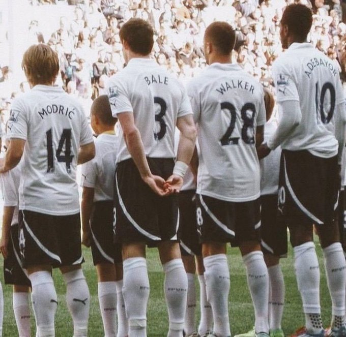Four Tottenham Hotspur players stand side-by-side on the pitch, their backs to the camera, wearing white jerseys displaying the names "MODRIĆ 14," "BALE 3," "WALKER 28," and "ADEBAYOR 10" in black lettering. In the context of the "Bitcoin in 2008" post, the image serves as a visual metaphor for the year 2010, when these players were part of a Tottenham squad that famously finished 4th in the Premier League—suggesting the post is humorously referencing the 2010 Bitcoin halving or another significant Bitcoin event tied to that date.
