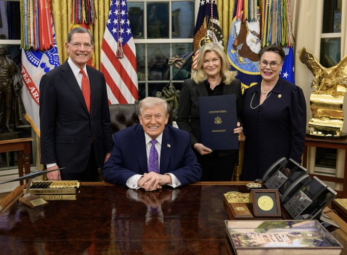 President Trump is pictured with three individuals, one holding a document labeled "United States Congress," in front of the American flag. This image directly relates to the post's call for the passage of the "Bitcoin and Crypto Clarity Act," suggesting a potential endorsement or signing ceremony.