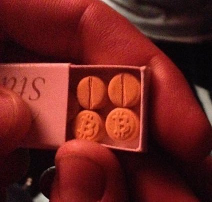 A hand holds open a small white box containing four orange Bitcoin-shaped pills marked with the "₿" symbol, resembling prescription medication with partial text "as" visible on the packaging. The image humorously frames Bitcoin as addictive "medicine," reinforcing the post's message that those who avoided buying more in 2013 missed out—and that true believers in Bitcoin focus on long-term wealth preservation over short-term fiat profits.