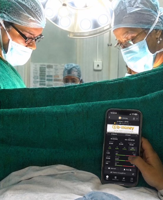 Surgeons in scrubs and masks perform an operation while someone holds a phone displaying the Binance BTC-money page, showing a Bitcoin (BTC) balance and 0.668 USDT conversion.