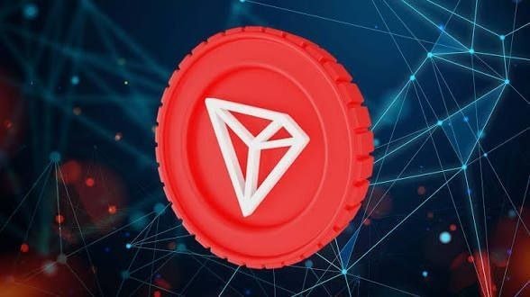 A red cryptocurrency token featuring a white triangular logo, displayed against a dark blue background with network connection lines.