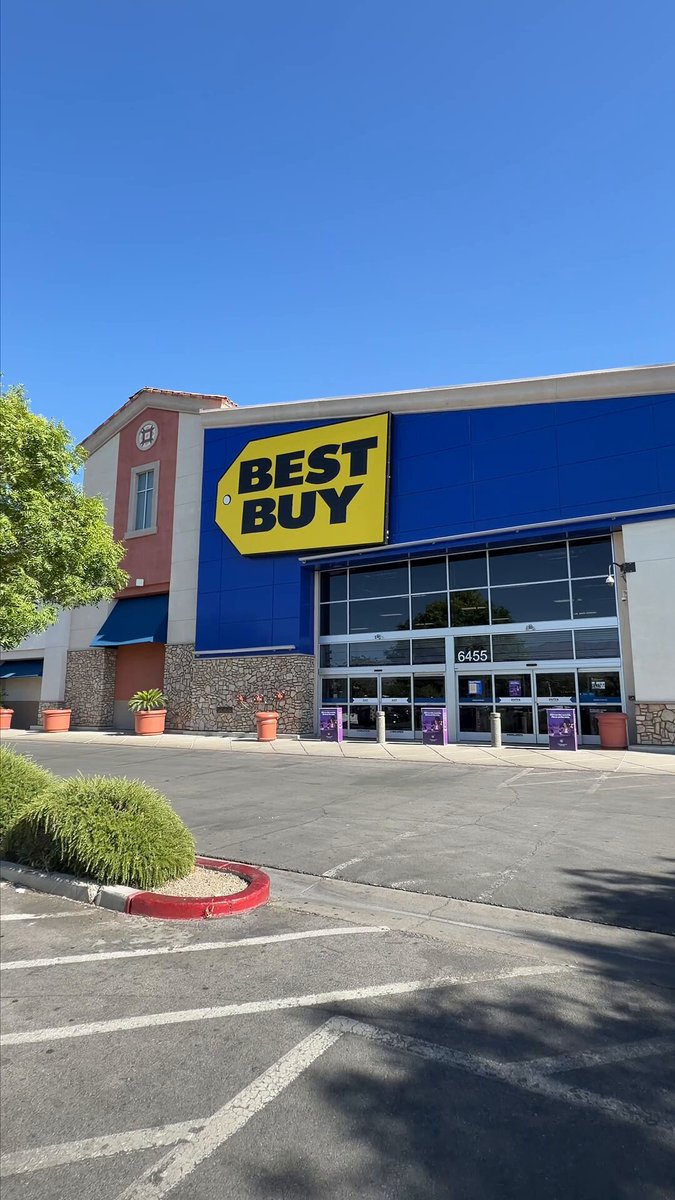 The image shows a Best Buy store with its blue sign displayed prominently above the entrance, indicating that it's open for business. The store has two @BestBuy stores located within Las Vegas, Nevada.