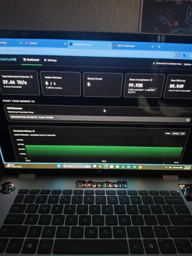 A laptop screen displaying what appears to be a mining dashboard with various metrics including hash rate, workers, and earnings statistics.