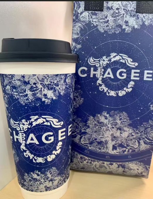 A reusable cup and matching paper bag both featuring blue and white celestial/astrological designs and the 'CHAGEE' tea company logo.