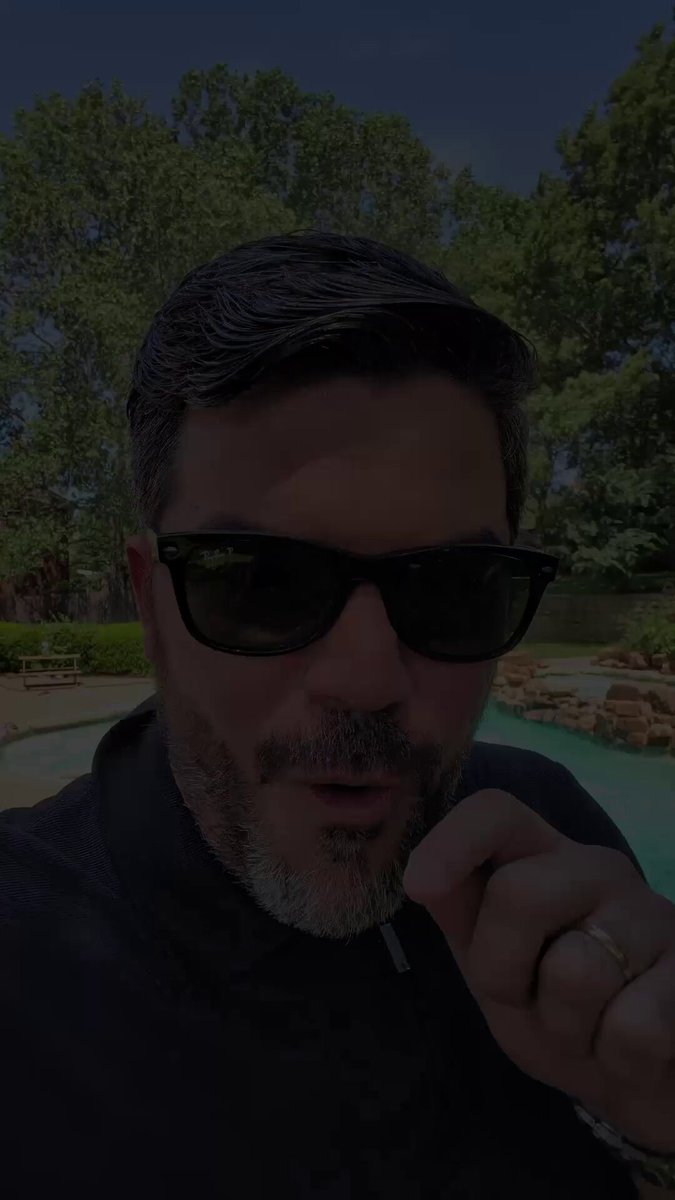 The image features a man wearing sunglasses, standing next to a pool or pond with trees in the background. The man appears to be posing for a photo while holding a cigarette. There are also some words related to Bitcoin and Finances visible in the image.