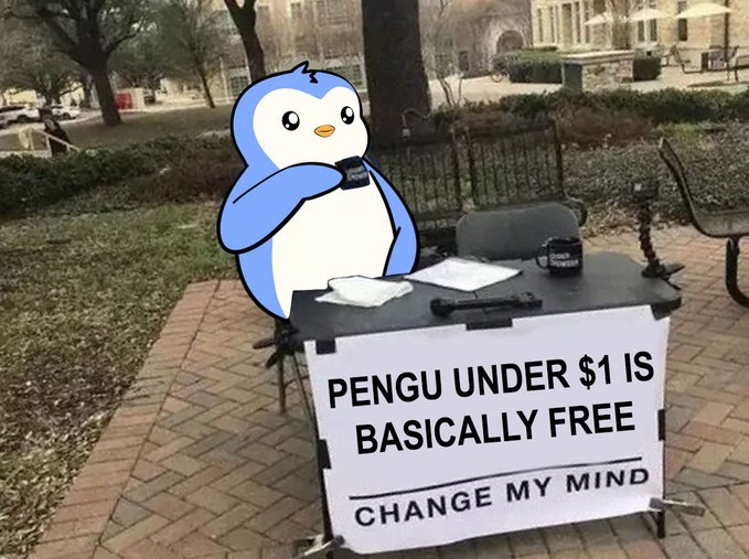 An outdoor 'Change My Mind' debate-style street sign reading 'PENGU UNDER $1 IS BASICALLY FREE,' accompanied by a cartoon penguin cutout holding a coffee cup.