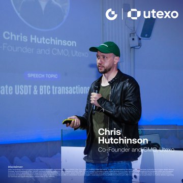 The image features a man wearing a green hat standing behind a podium at an event. He appears to be giving a speech or presentation, with his hand holding a microphone. The backdrop of the scene includes a blue wall and a projector screen displaying information about Bitcoin and stablecoins. The text "Let's bring USDT back to Bitcoin" is visible in the image as well.