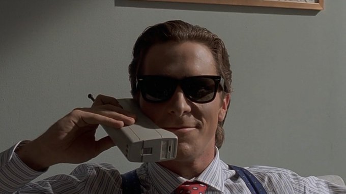 A man in sunglasses holds a brick-style cell phone to his ear, smiling slyly while dressed in a striped shirt and suspenders. The image evokes a smug, insider-trader confidence, pairing with the post's caption mocking people who panic-sell before a market rebound.