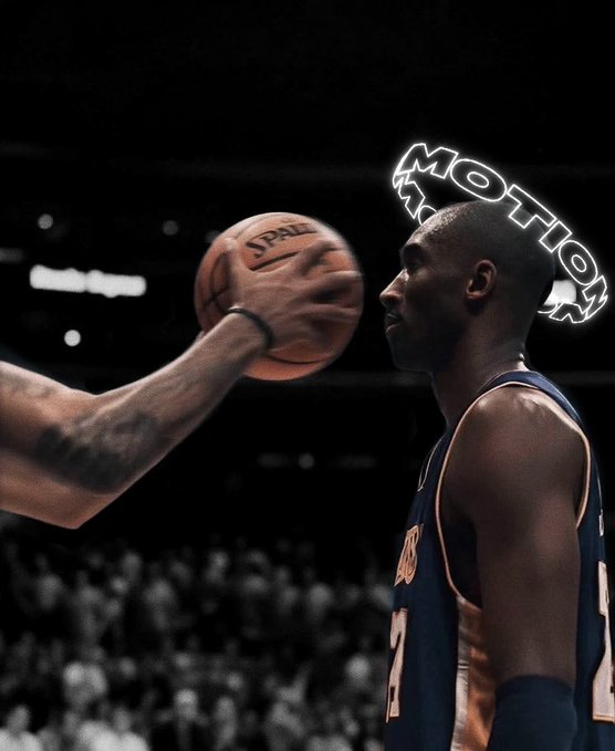 A basketball player wearing a New York jersey and a glowing neon 'MOTHER' headband holds a Spalding basketball, with an opposing player's tattooed arm visible in the foreground during a game.