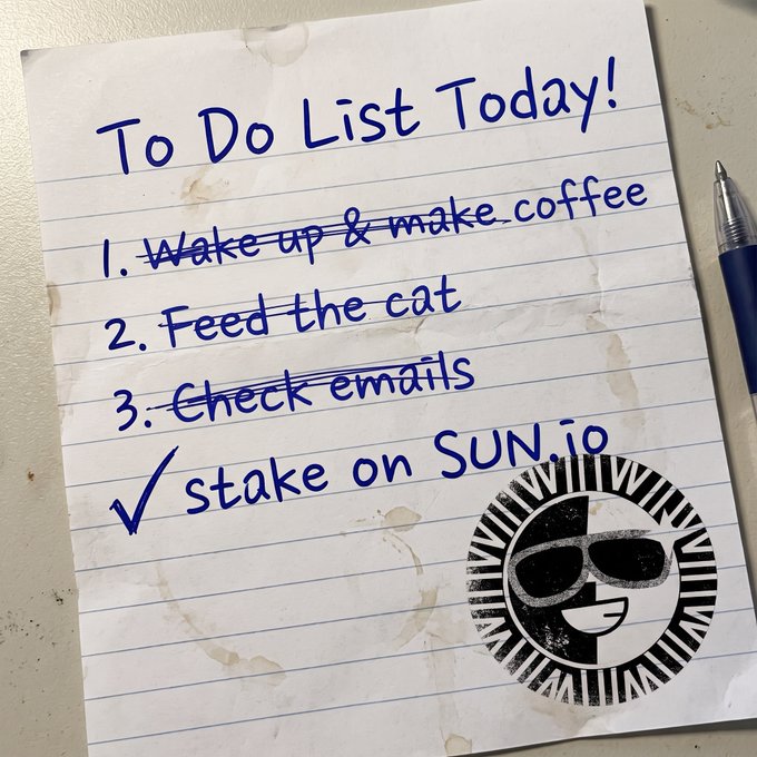 A handwritten "To Do List Today!" shows checked-off tasks like "Wake up & make coffee," "Feed the cat," and "Check emails," with a final item reading "✓ stake on SUN.io" alongside the SUN.io logo. The image humorously frames staking SUN.io as an essential daily priority—right up there with coffee and feeding the cat—reinforcing the post's lighthearted message about focusing on small, meaningful tasks.