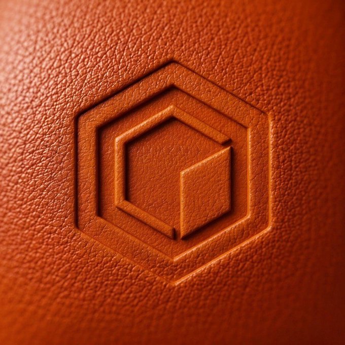 A close-up of an embossed hexagonal Core (CORE) logo on textured orange leather, symbolizing the long-term investment of 1,000 CORE tokens staked for 15 years to fund a daughter's future milestones.
