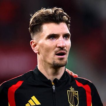 The image shows a young male soccer player wearing a black Belgium national team jacket with red and yellow accents, featuring the Adidas logo and the Belgian Royal Football Association crest. His focused expression and athletic appearance complement the post's sentiment of him being a valuable and underrated signing.