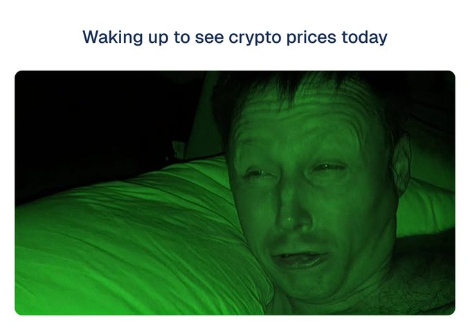 A meme-style image with the caption 'Waking up to see crypto prices today' showing a close-up, green-tinted photo of a man lying in bed with a distressed, grimacing expression.