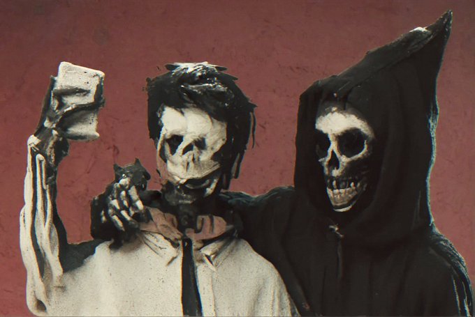 A gritty illustration of two skeletal figures, one in a white shirt holding up a brick and the other in a black hooded cloak with its arm around the first.
